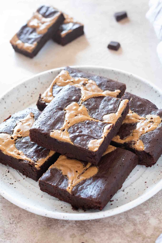 Peanut butter brownies piled on a white plate