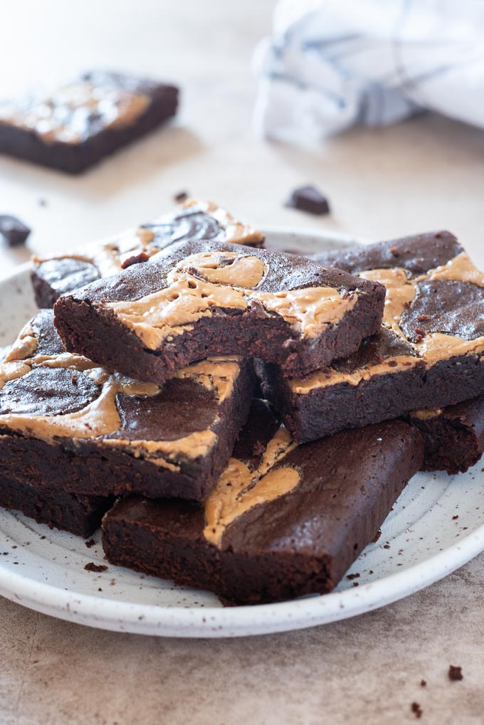 Peanut butter brownies on a plate with bite out of top brownie