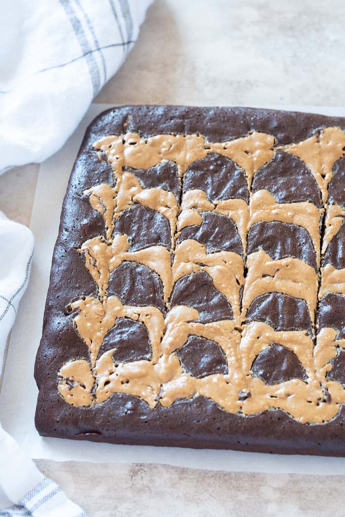 Peanut butter swirl brownies on parchment before cutting
