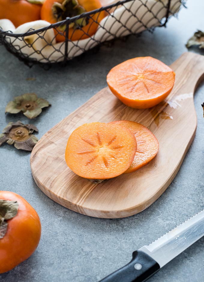 Slices of fuyu persimmon on a cutting board