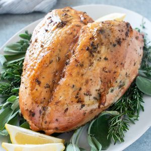 Herb and garlic roasted turkey breast on a serving platter