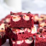 Stack of red velvet brownies with glass of milk