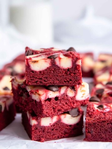 Stack of red velvet brownies with glass of milk