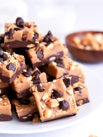 Squares of chocolate peanut butter fudge piled on a white plate