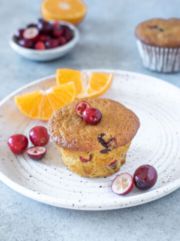 Healthy cranberry orange muffin on a white plate