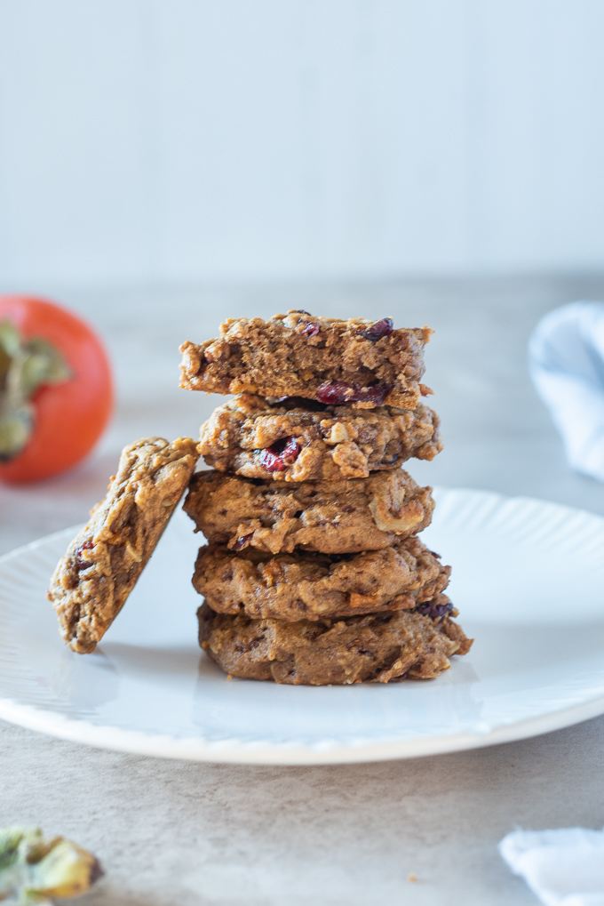 Stack of persimmon cookies on a plate with a cookie leaning on left side