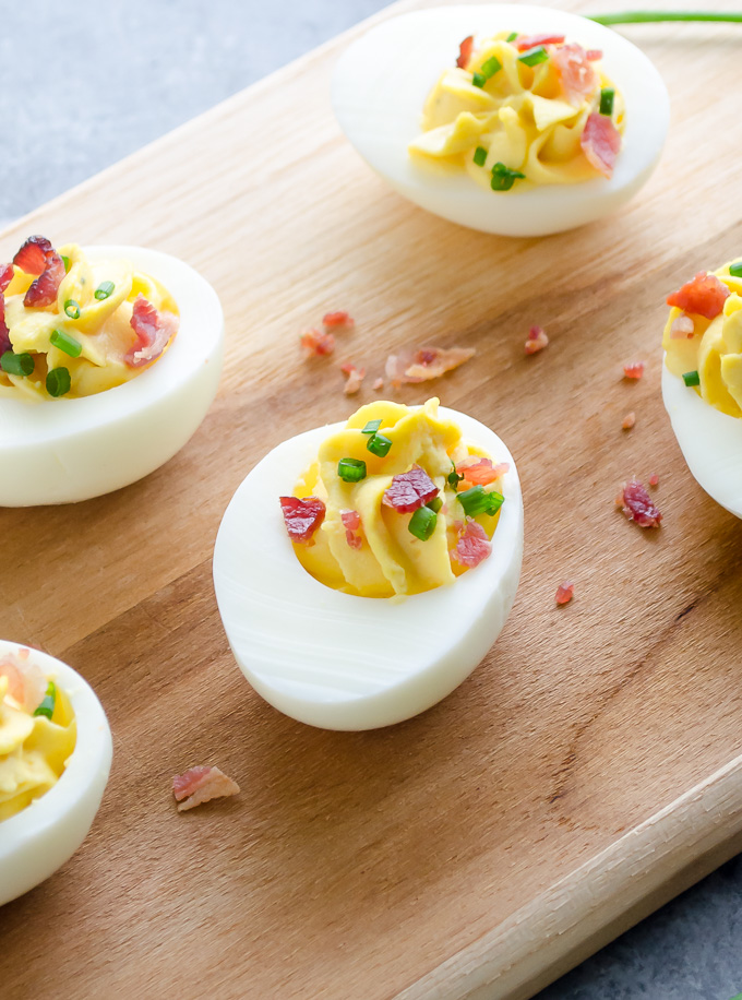 Deviled eggs with bacon on a wooden board