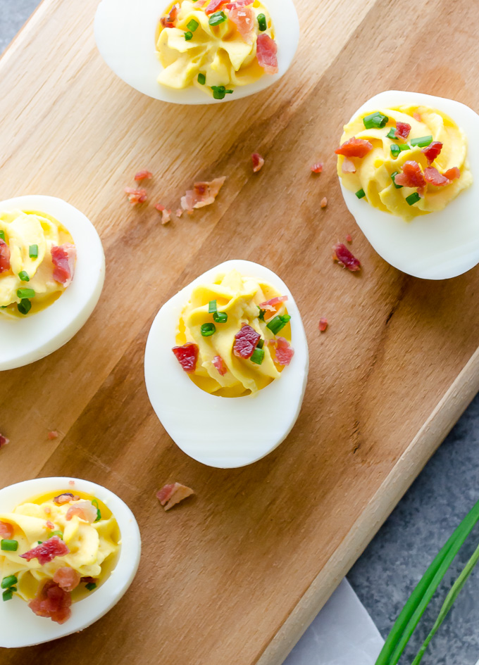 Deviled eggs topped with bacon and chives