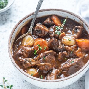 Bowl of beef bourguignon with spoon digging in