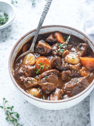 Bowl of beef bourguignon with spoon digging in
