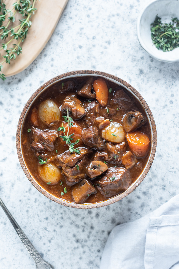 Bowl of beef bourguignon with sprig of thyme on top
