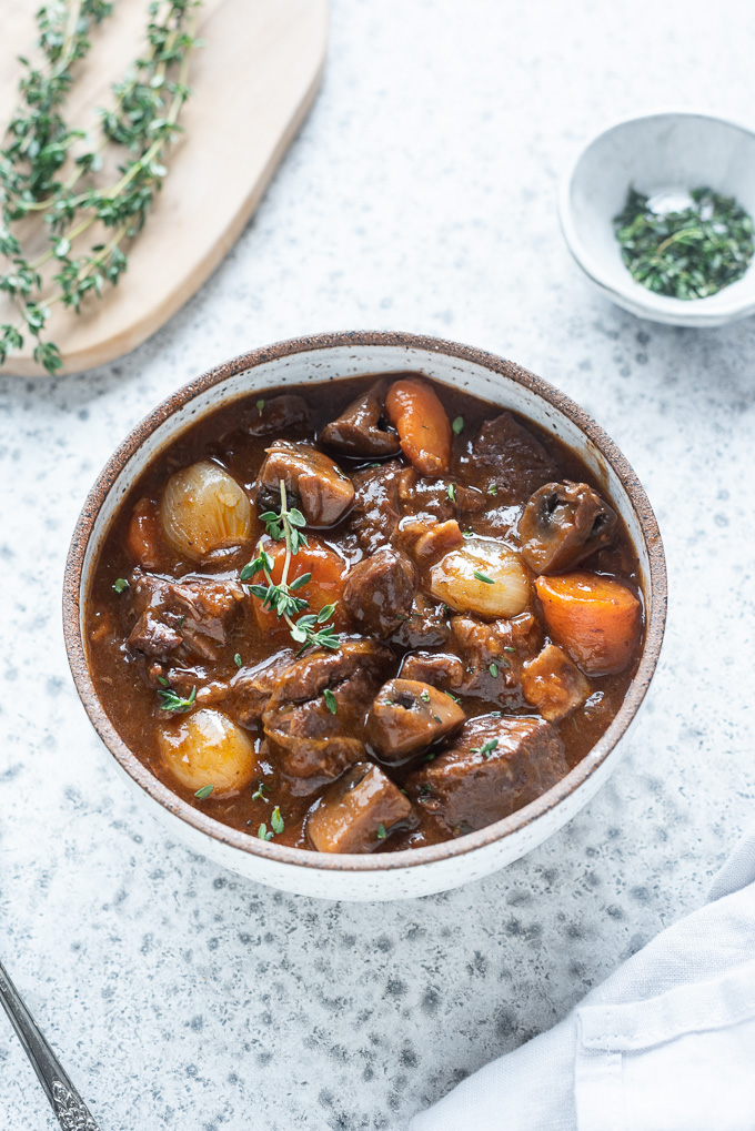 Bowl of instant pot beef bourguignon with fresh thyme