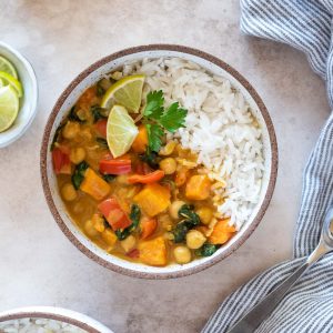 Instant pot sweet potato chickpea curry in a bowl with lime and cilantro