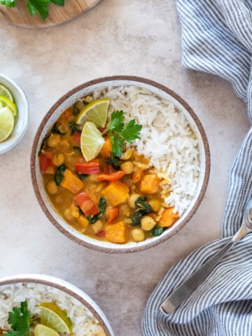 Instant pot sweet potato chickpea curry in a bowl with lime and cilantro