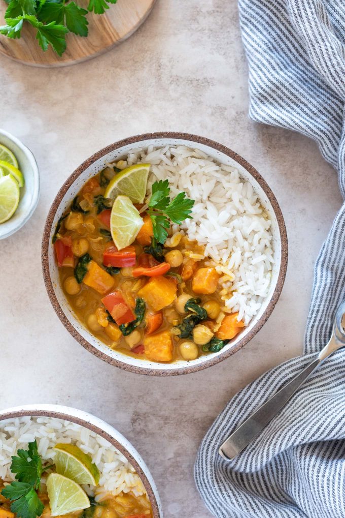 Instant pot sweet potato chickpea curry in a bowl with lime and cilantro