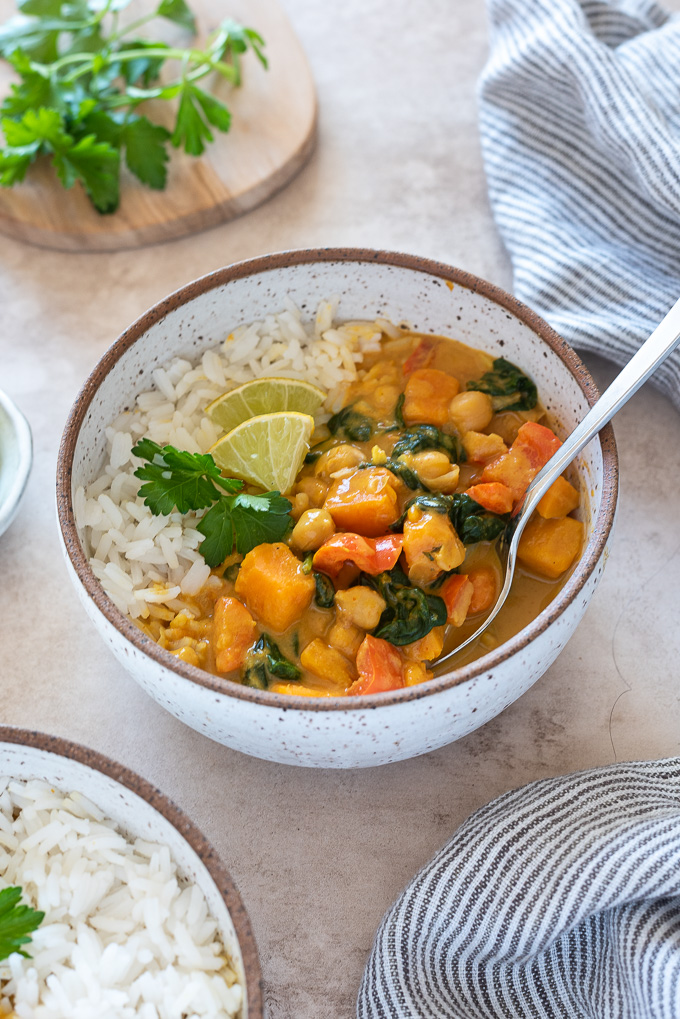 Sweet potato chickpea curry in a bowl with spoon digging in