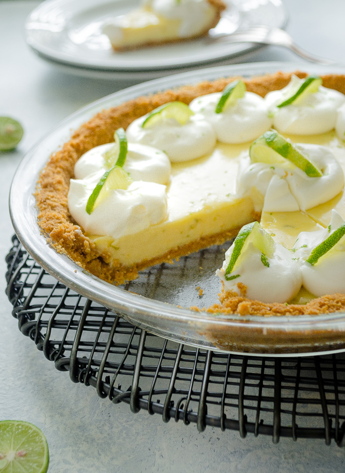 Key lime pie in pie plate with a slice missing