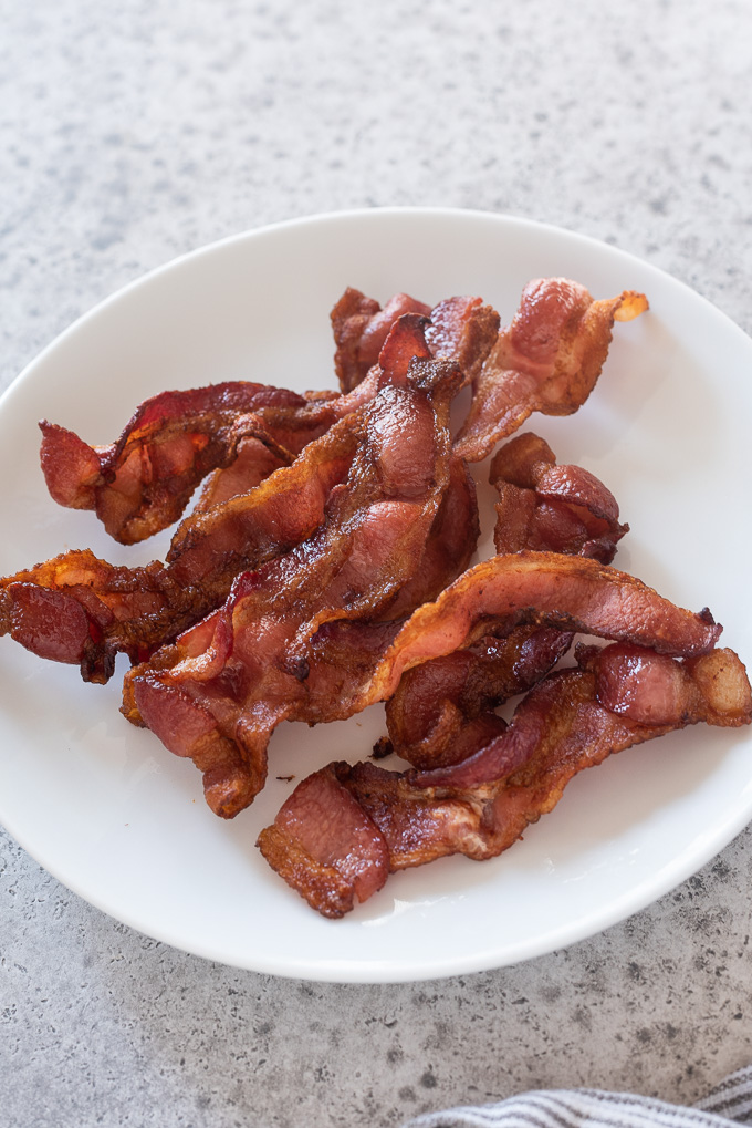 Slices of crispy air fryer bacon on a plate