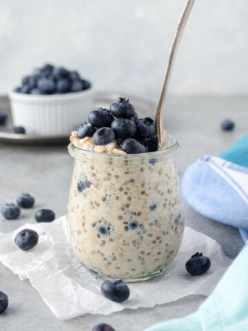 Blueberry overnight oats in a jar with spoon buried inside