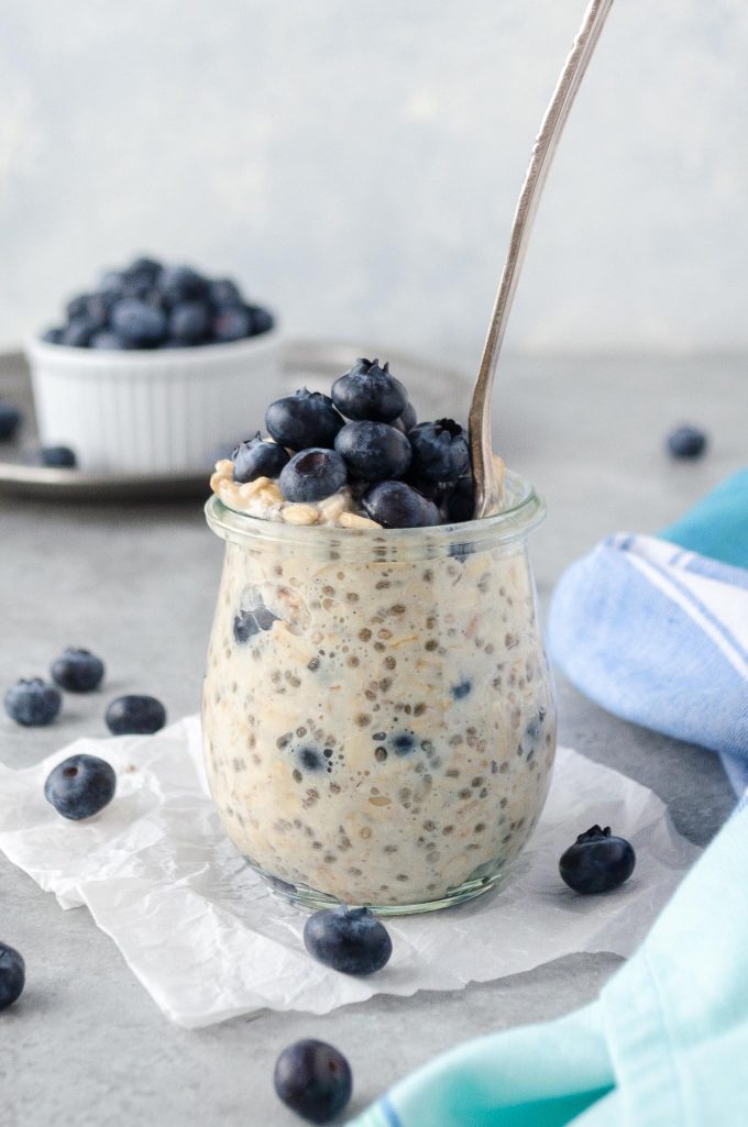 Blueberry overnight oats in a jar with spoon buried inside