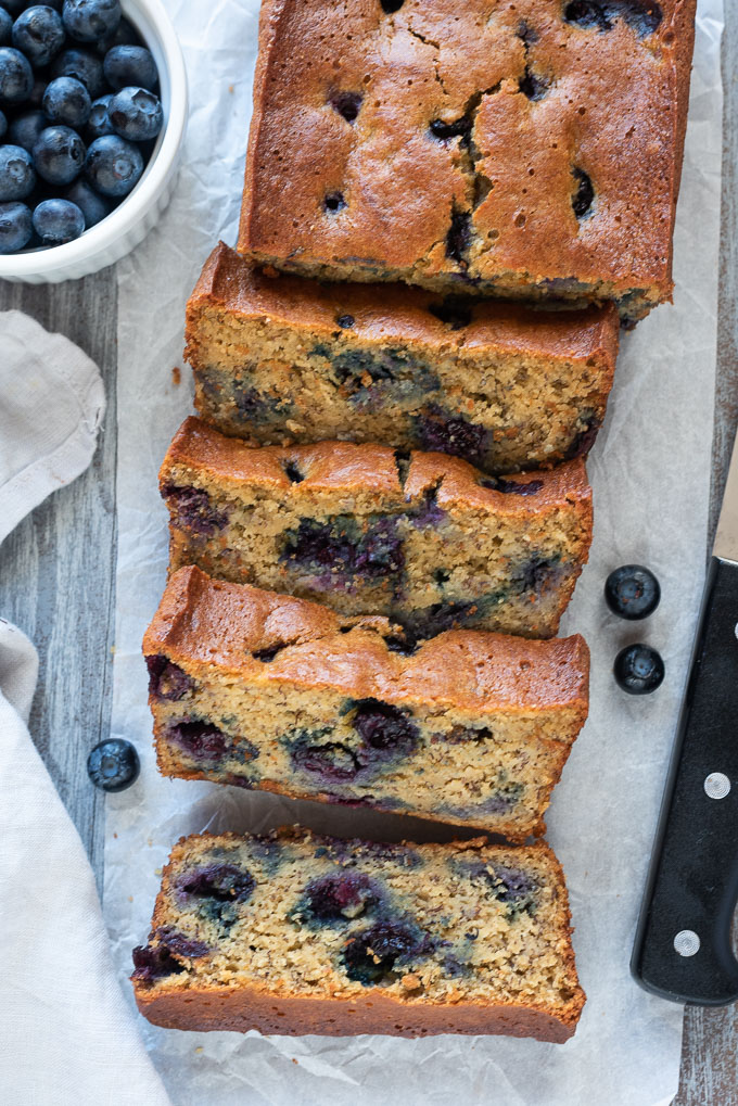 Banana Blueberry Bread sliced with fresh blueberries all around