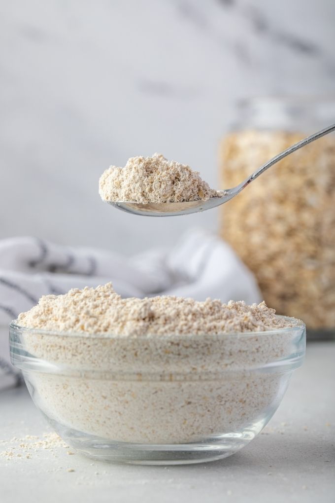 Spoonful of oat flour over a bowl