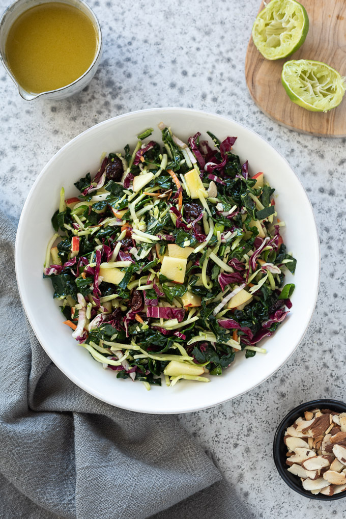 Kale apple slaw with honey lime dressing in a white bowl