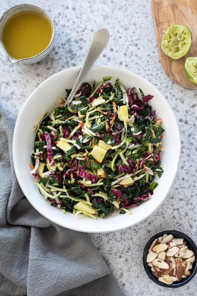 Kale slaw with honey lime dressing in a white bowl