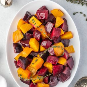 Roasted beets on a platter with thyme sprigs