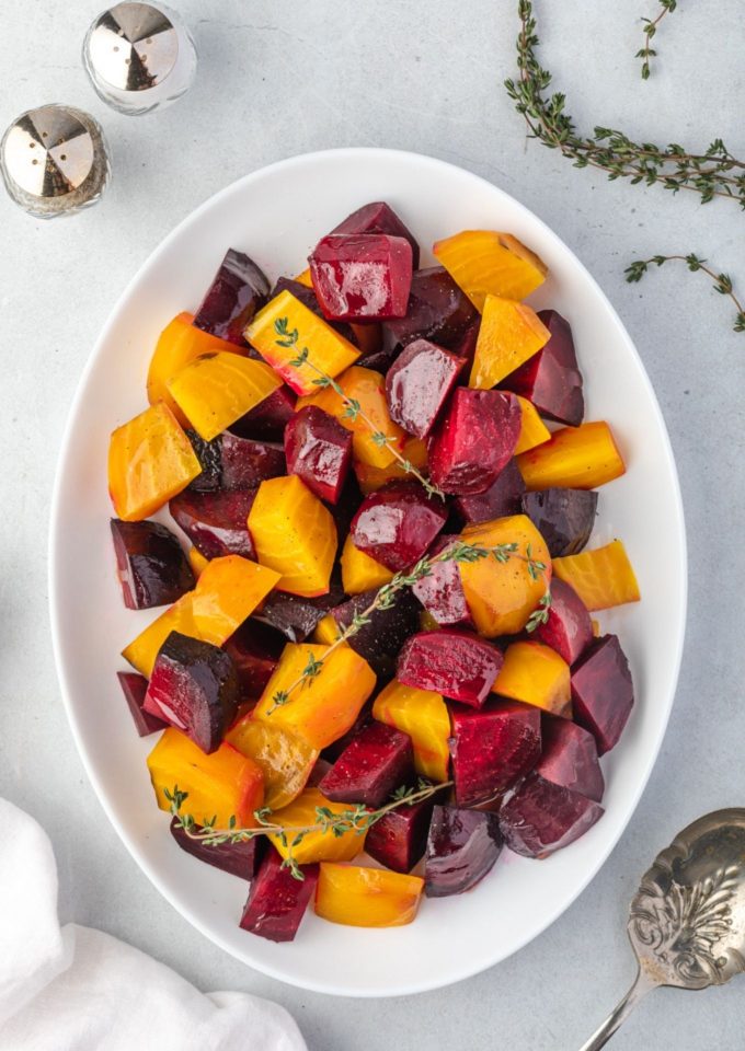Roasted beets on a platter with thyme sprigs