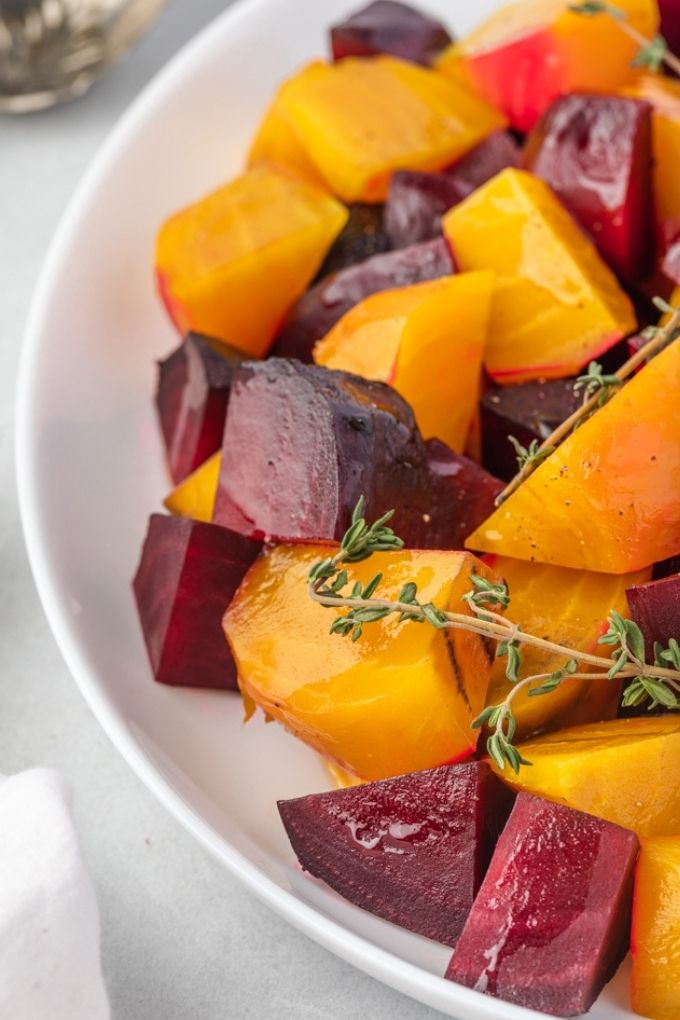 Roasted beets on a platter with thyme spring