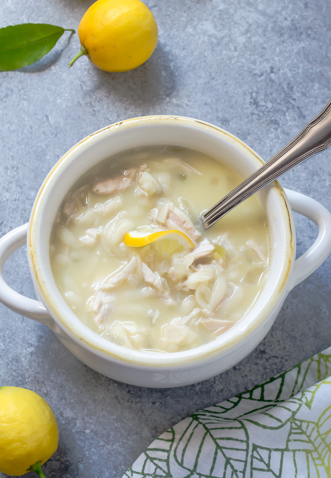 Slow cooker Greek avgolemono soup in a bowl with spoon buried inside