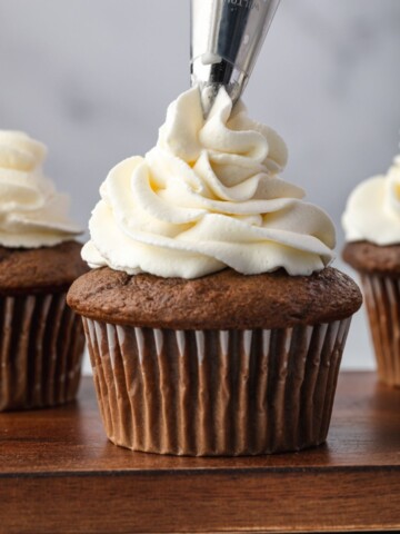 Stabilized whipped cream piping onto a cupcake