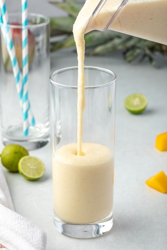Pouring tropical smoothie into a glass