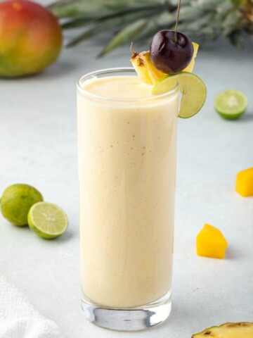 Tropical smoothie with pineapple cherry and lime on rim