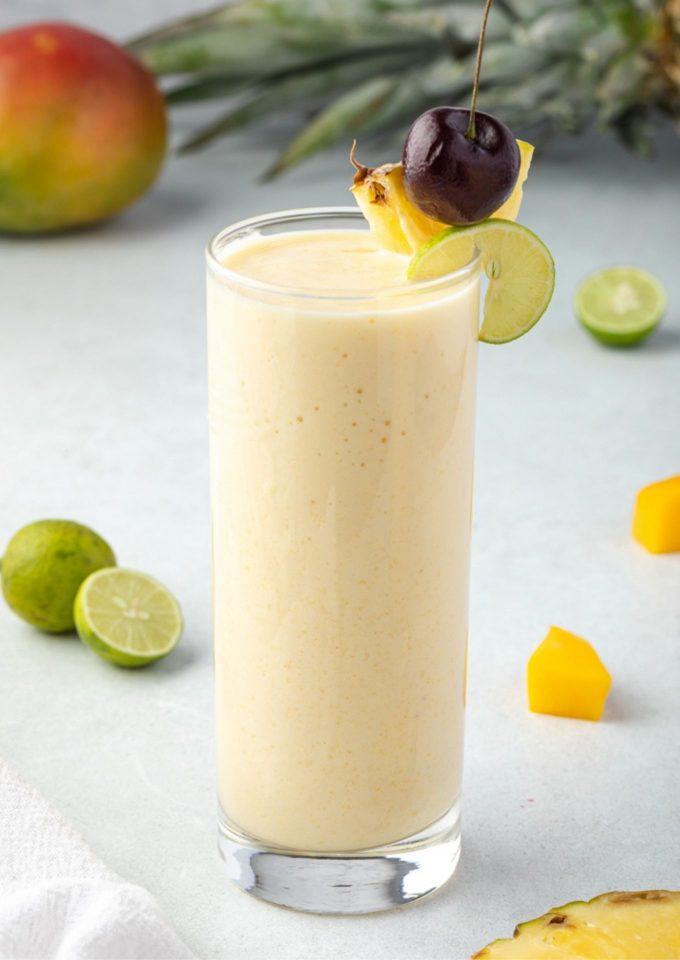 Tropical smoothie with pineapple cherry and lime on rim