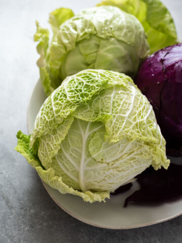 Napa cabbage on a plate with purple and green heads.