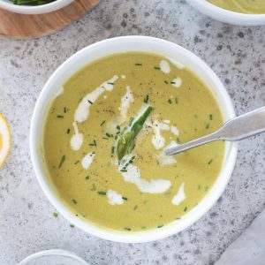 Creamy asparagus soup in a bowl with chives on top