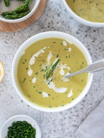 Creamy asparagus soup in a bowl with chives on top