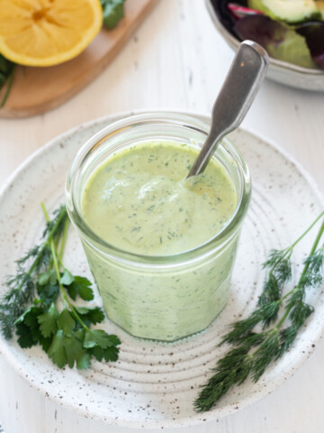 Green goddess dressing in a jar with a spoon
