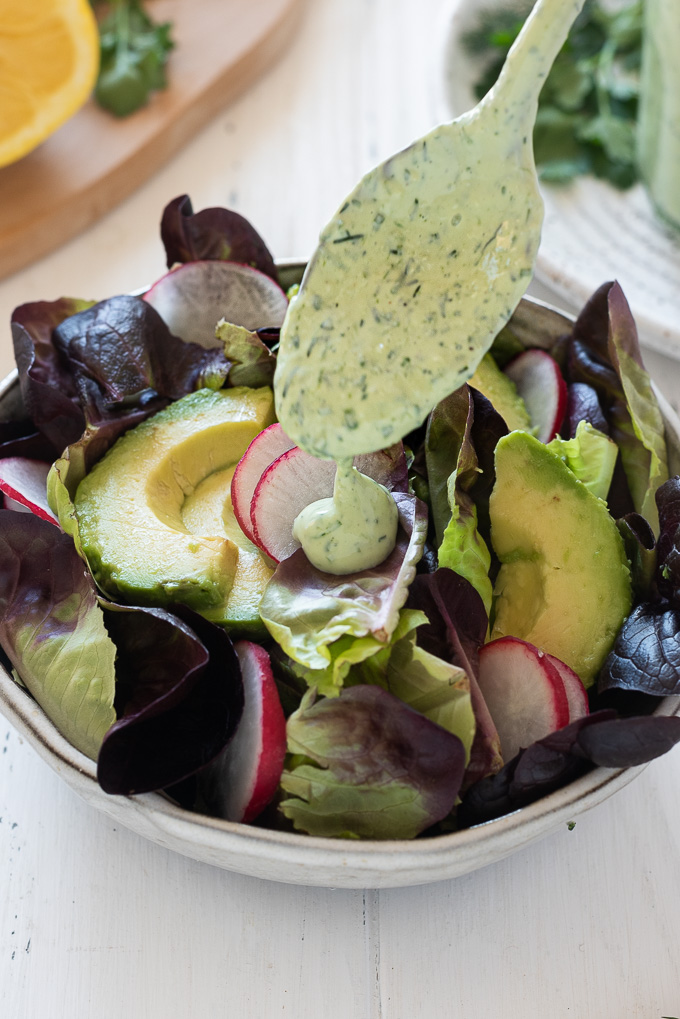 Green goddess dressing drizzling onto a salad
