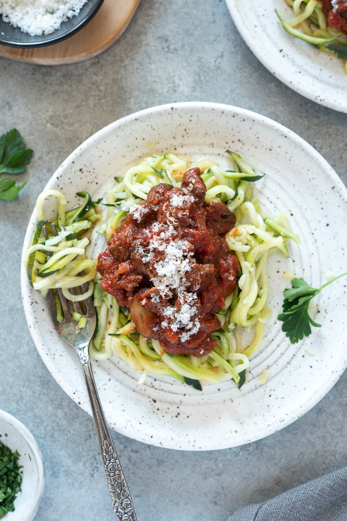 Meat sauce over zoodles on a white plate
