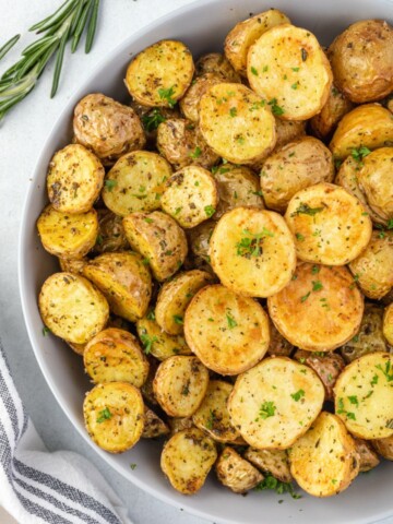 Air fryer potatoes in a bowl with rosemary