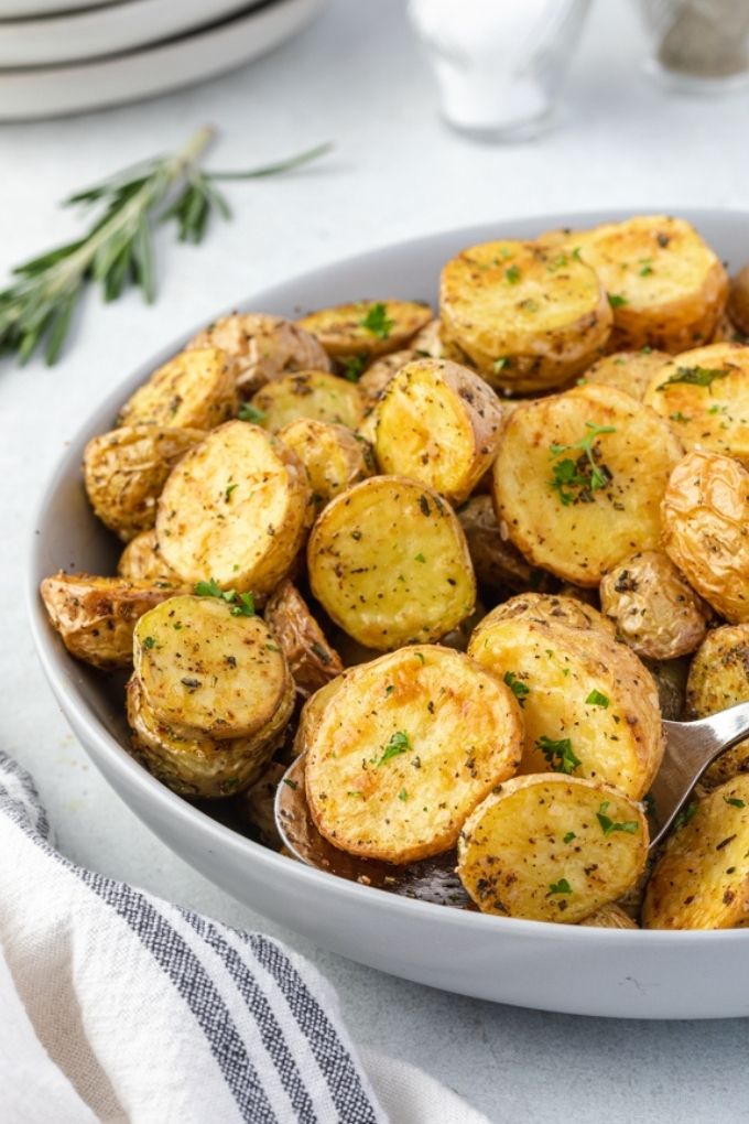 Air fryer roasted potatoes in a bowl with rosemary