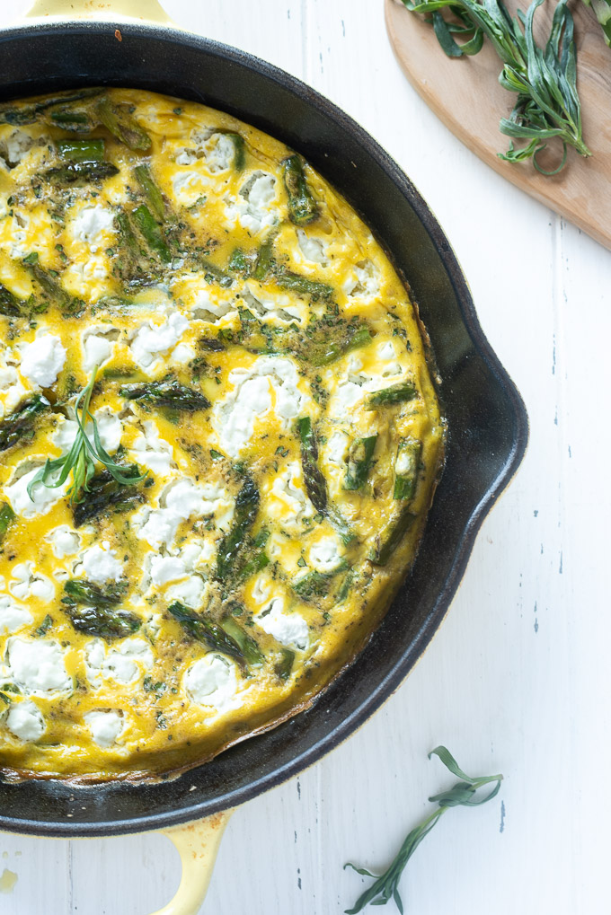 Asparagus frittata in a skillet with goat cheese and tarragon