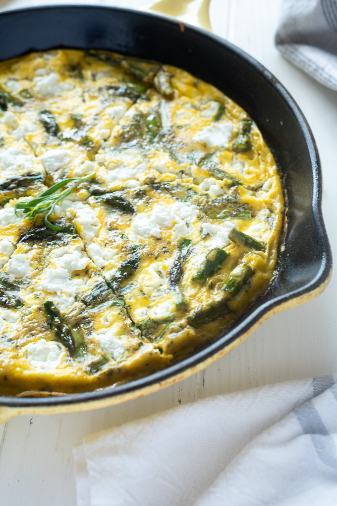 Asparagus frittata with goat cheese sliced in a cast iron skillet