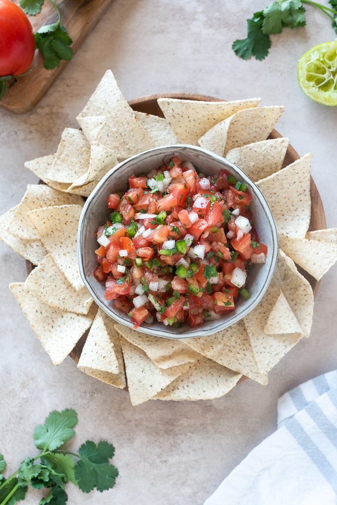 Homemade pico de gallo in a bowl surrounded by tortilla chips