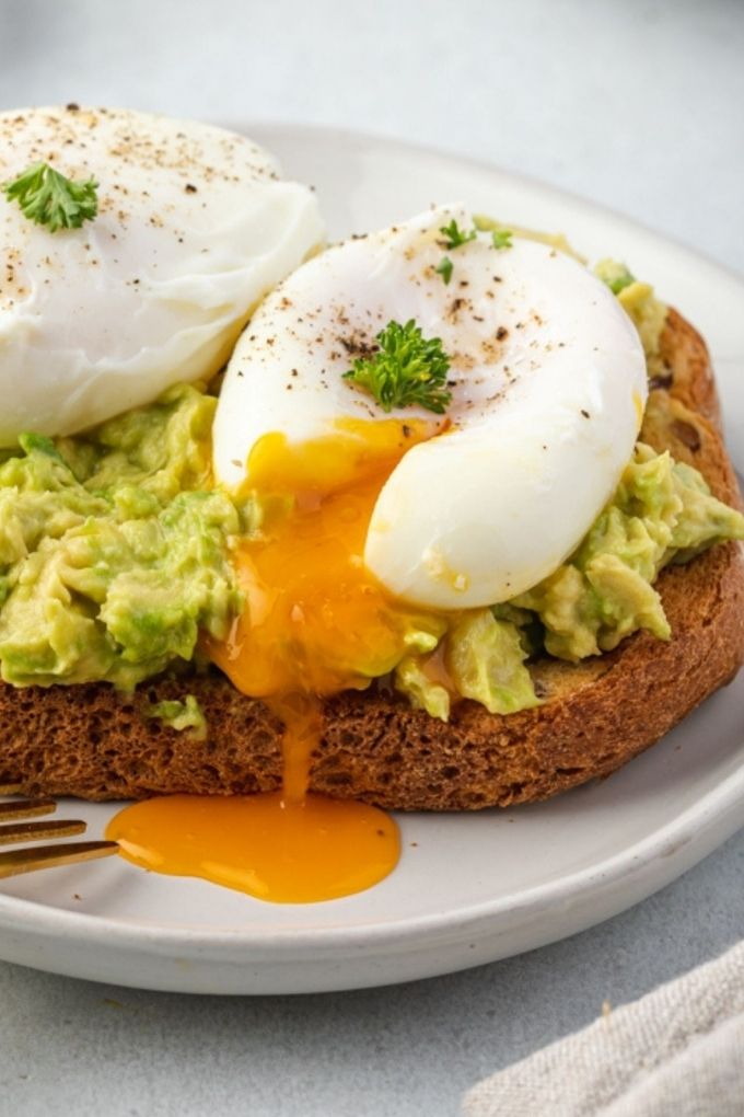 Poached eggs on avocado toast with yolk running