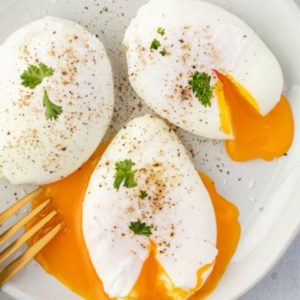 Poached eggs on a plate with parsley and runny yolks