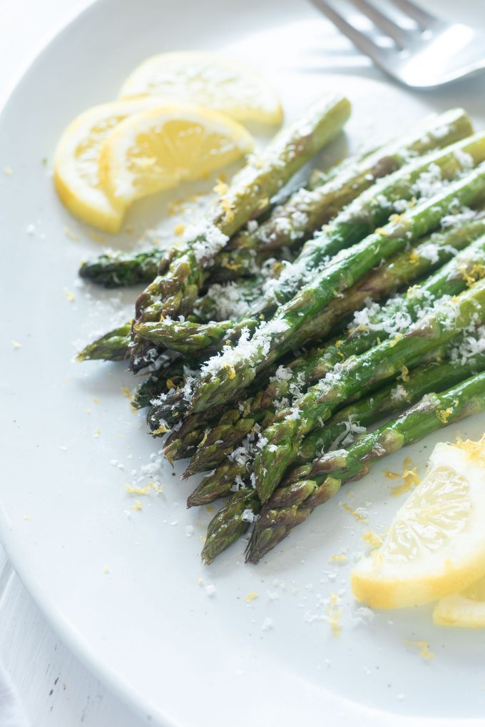 Roasted asparagus on a platter with parmesan cheese on top